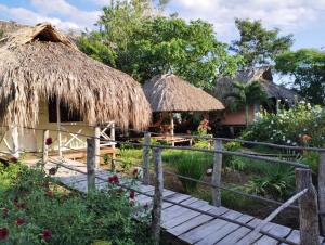 um resort com cabanas de palha e uma ponte de madeira em Cabañas La Múcura em San Onofre