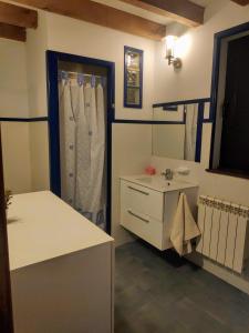 La salle de bains est pourvue d'un lavabo et d'une coiffeuse avec un miroir. dans l'établissement Casa con encanto en Cuena, 