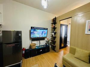 uma sala de estar com uma televisão e um frigorífico em 1bedroom With Balcony Taguig Near Bgc mc kinley em Manila