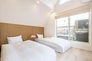 2 camas en una habitación con ventana en Hotel STAY ARI Higashishinjuku en Tokio