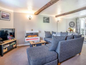 a living room with two couches and a fireplace at The Llandeilo Cottage in Llandeilo