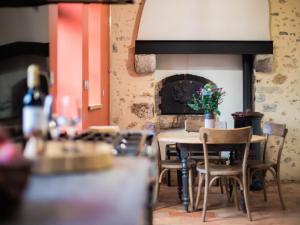 a dining room with a table and a fireplace at Luxe et tranquillité au vert: maison 6 chambres, piscine, proche du Mans, idéale familles et groupes - FR-1-410-361 in Parigné-lʼÉvêque