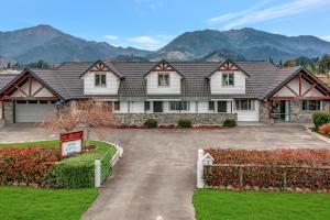 a large house with mountains in the background at Hanmer Apartments in Hanmer Springs