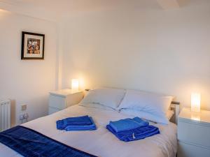 a white bed with two blue towels on it at The Old Canoe Club in Millbrook