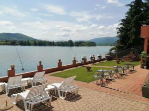 a row of chairs and tables on a patio next to a lake at Apartments with a parking space Sabljak Selo, Gorski kotar - 21683 in Ogulin