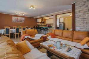 a living room with couches and a table and a kitchen at Apartments with a parking space Sabljak Selo, Gorski kotar - 21683 in Ogulin