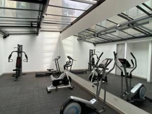 een fitnessruimte met diverse loopbanden en hometrainers bij Unicentro North Retreat 2 Rooms in Bogota