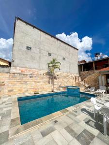 a swimming pool in front of a brick building at Casa Santos - Pirenópolis in Pirenópolis