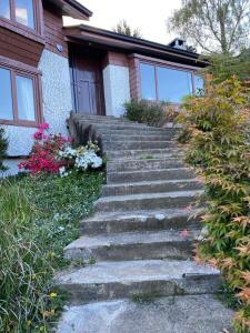 un conjunto de escaleras de piedra que conducen a una casa en Felices Sueños, Entre Volcanes ., en Puerto Varas