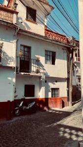 a motorcycle parked in front of a white building at Casa Roma in Taxco de Alarcón