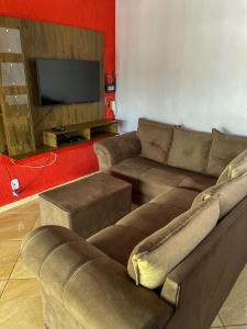 a living room with a couch and a flat screen tv at Casa Santos - Pirenópolis in Pirenópolis