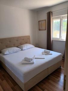 Schlafzimmer mit einem großen weißen Bett und einem Fenster in der Unterkunft Family friendly house with a swimming pool Sibenik - 21939 in Šibenik
