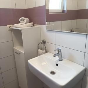 ein Badezimmer mit einem weißen Waschbecken und einem Spiegel in der Unterkunft Family friendly house with a swimming pool Sibenik - 21939 in Šibenik