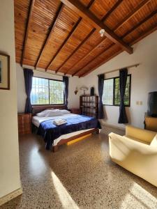 a bedroom with a bed and a couch at Casa de campo Jade, Rionegro in Rionegro