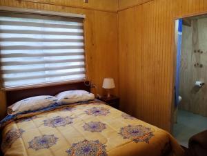 a bedroom with a bed with a window at Residencial 4 estaciones in Futaleufú