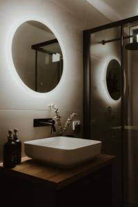 La salle de bains est pourvue d'un lavabo blanc et d'un miroir. dans l'établissement The Eco Cabin Tasmania, à Deloraine
