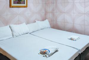a bed with two pillows and a towel on it at RedDoorz @ PVC Pension Haus in Tagum