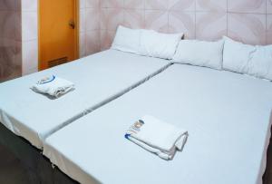 uma grande cama branca com duas toalhas em RedDoorz @ PVC Pension Haus em Tagum