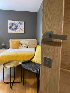 a bedroom with a bed and a door with a chair at 4- Lovely 1-bedroom serviced apartment West Midlands 