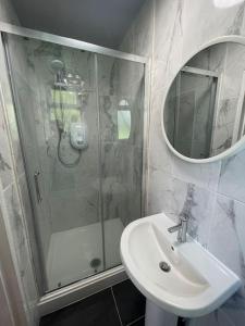 a bathroom with a shower and a sink and a mirror at 4- Lovely 1-bedroom serviced apartment West Midlands 