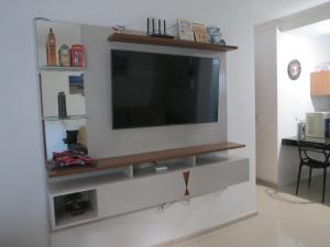 a living room with a television on a wall at Recanto do Mundaí - Apto 101 in Porto Seguro