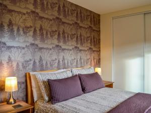 um quarto com uma cama com almofadas roxas em Swallow Lodge em Carsphairn