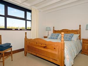 um quarto com uma cama de madeira e uma janela em Tai Bach em Treffynnon 