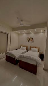 two twin beds in a room with a ceiling at DrizzleDrop Inn Chennai in Chennai