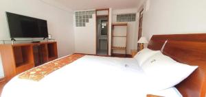 a bedroom with a bed and a flat screen tv at Hotel Romero Machupicchu in Machu Picchu