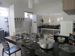 a kitchen with a table with wine glasses on it at Recanto do Mundaí - Apto 202 in Porto Seguro