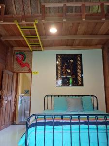 a bed in a room with a wooden ceiling at Omah Kepel Yogyakarta in Soprayan