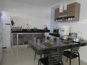 una cocina con una mesa con copas de vino. en Recanto do Mundaí - Apto 202, en Porto Seguro