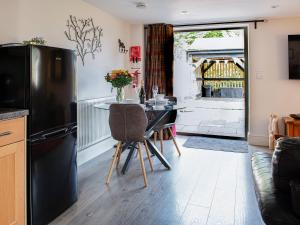 a kitchen with a table and a black refrigerator at Little Willow in Saint Columb Major