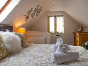 a bedroom with towels on top of a bed at Little Willow in Saint Columb Major