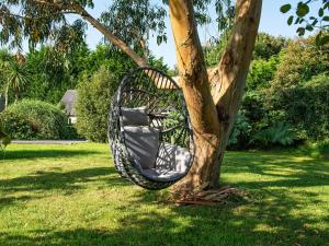 a black chair in a tree in a yard at Little Willow in Saint Columb Major