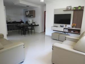 a living room with a television and a dining room at Recanto do Mundaí - Apto 202 in Porto Seguro