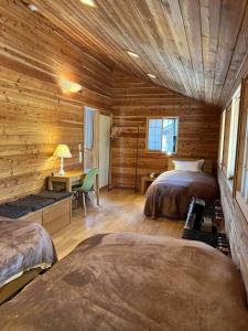 una camera da letto in stile baita di tronchi con 2 letti e una scrivania di 貸し別荘 Key of Private Villa 'ムササビハウス' a Kita-karuizawa