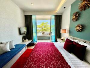 a bedroom with a large bed with a red rug at Mukrada House Boutique Hometel Krabi in Klong Muang Beach