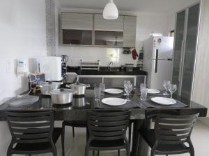 a kitchen with a table with chairs and a refrigerator at Recanto do Mundaí - Apto 201 in Porto Seguro