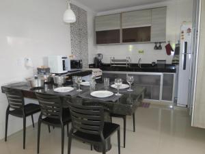 a kitchen with a table and chairs with wine glasses at Recanto do Mundaí - Apto 201 in Porto Seguro