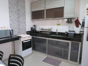 uma pequena cozinha com um lavatório e um fogão em Recanto do Mundaí - Apto 201 em Porto Seguro