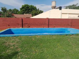 una piscina azul en un campo junto a una pared de ladrillo en No Reservar en San Vicente