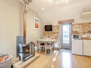 a living room with a fireplace and a table with chairs at Walnut Cottage - Ukc6632 in Pentney