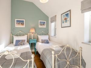 Walnut Cottage - Ukc6632 في Pentney: غرفة نوم بسريرين وطاولة زرقاء