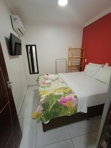 マラゴージにあるPousada Canto dos Coraisの赤い壁のベッドルーム1室(ベッド1台付)