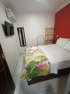 um quarto com uma cama com um cobertor floral em Pousada Canto dos Corais em Maragogi