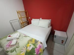 um pequeno quarto com uma cama com um telefone em Pousada Canto dos Corais em Maragogi