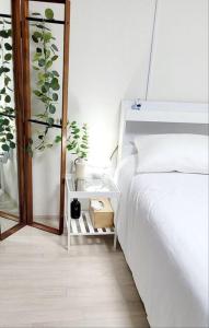 a bedroom with a white bed and a plant at Stay Mono in Incheon