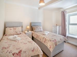 a bedroom with two beds and a window at The Llandeilo Cottage in Llandeilo