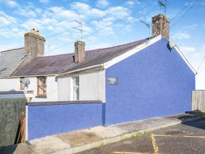 a blue and white house with a blue wall at The Llandeilo Cottage in Llandeilo